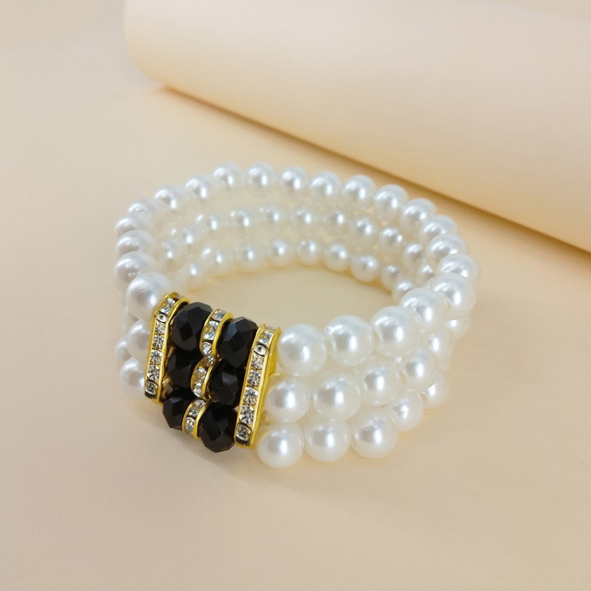 Triple-Strand Pearl & Black Crystal Stretch Bracelet – Elegant Gold-Tone Statement Piece